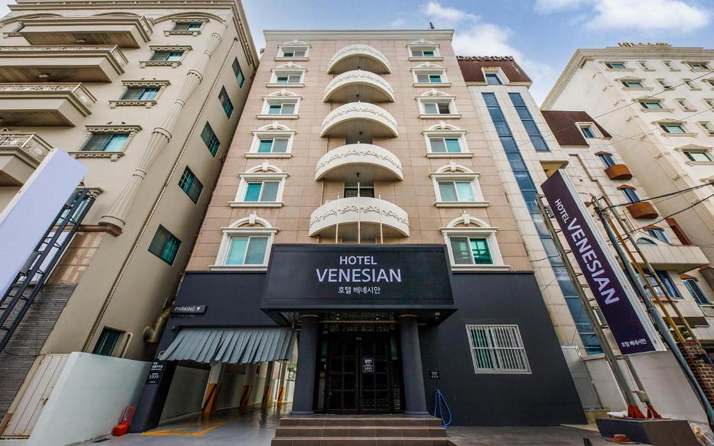 un edificio de apartamentos alto con un cartel para el hotel vyss istg en Hotel Venesian, en Pohang
