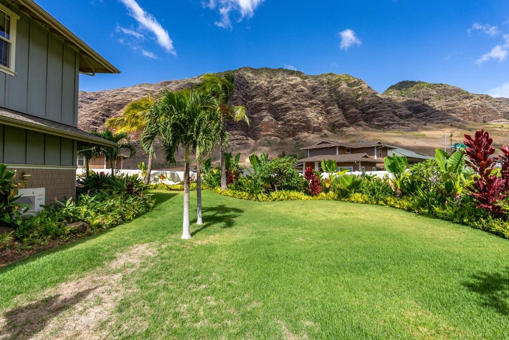 @Marbella Lane-Pōmaika'i LoveNest Ocean+MT View في Waianae: حديقة أمام منزل مع جبل في الخلفية