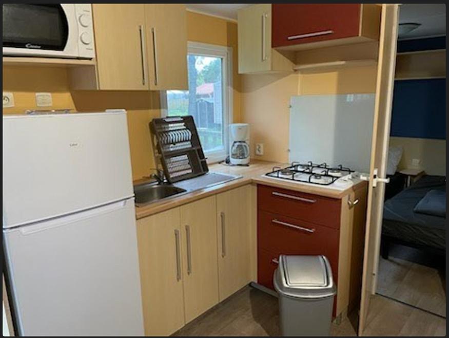 a small kitchen with a white refrigerator and a sink at PUY DU FOU 6P F028 in La Boissière-de-Montaigu