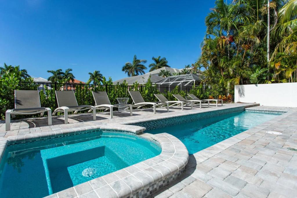 a swimming pool with lounge chairs and a swimming pool at Sorrento Vacation Rental in Naples