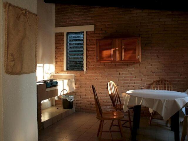 Cette chambre dispose d'une table, de chaises et d'un mur en briques. dans l'établissement Club Santa Maria, à Cuernavaca
