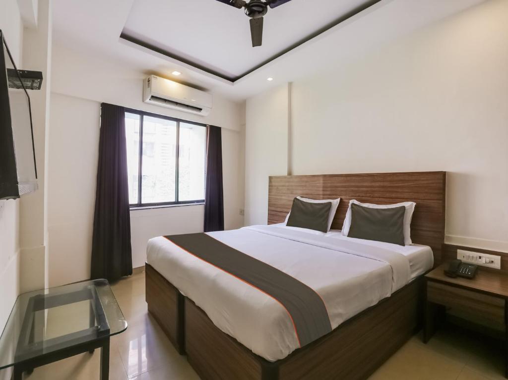 孟買的住宿－Townhouse Marol Near Mumbai International Airport，一间卧室设有一张大床和一个窗户。