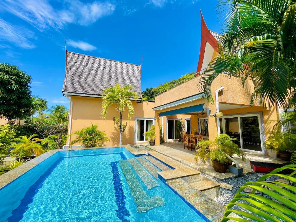 a villa with a swimming pool in front of a house at Pool Villa Mali in Ko Chang