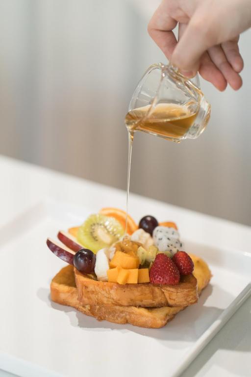 French toast topped with fresh fruit and poured syrup.