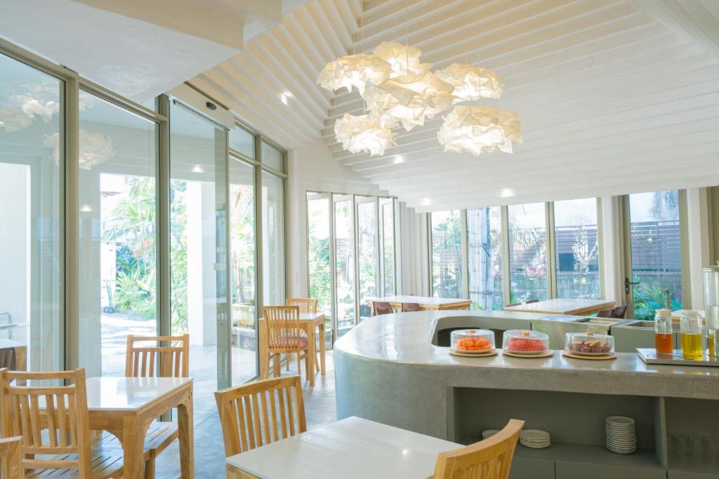 A bright breakfast room with window-side tables and a central buffet island.