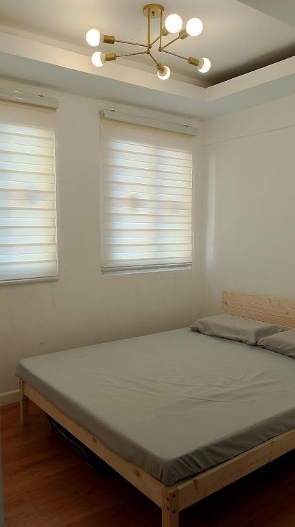 a bed in a room with two windows at Malvar Lodge in San Isidro Sur