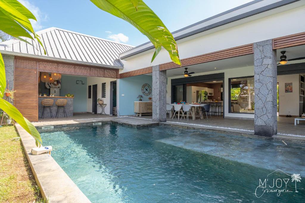 a swimming pool in front of a house at TY KAZ PARADIS, villa avec piscine pleine de charme in Ravine des Cabris