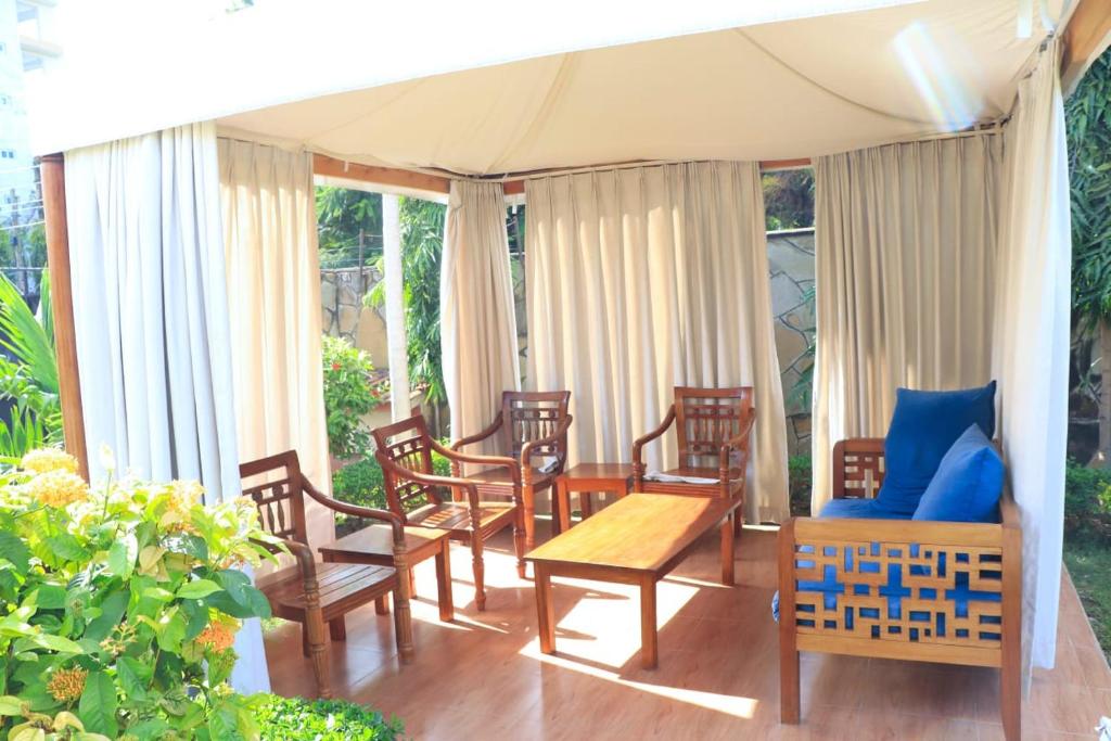 eine Veranda mit einem Tisch und Stühlen sowie ein Zelt in der Unterkunft Swahili House Mweru villa in Mombasa