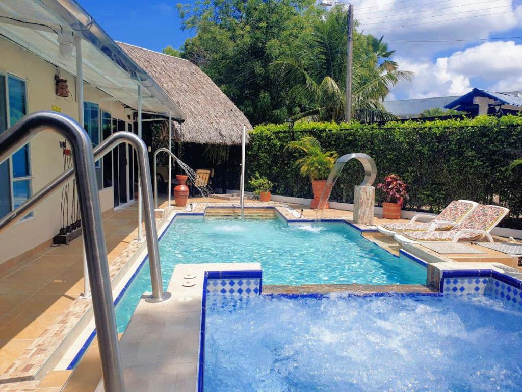 a swimming pool with two chairs and a house at Villa Marfelia Spa in Ricaurte