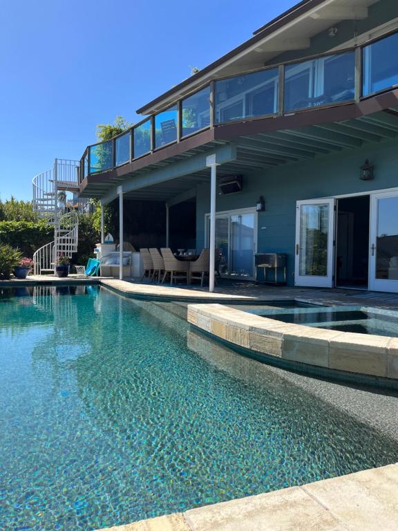 a house with a swimming pool in front of a house at La Playa Place Getaway in San Diego
