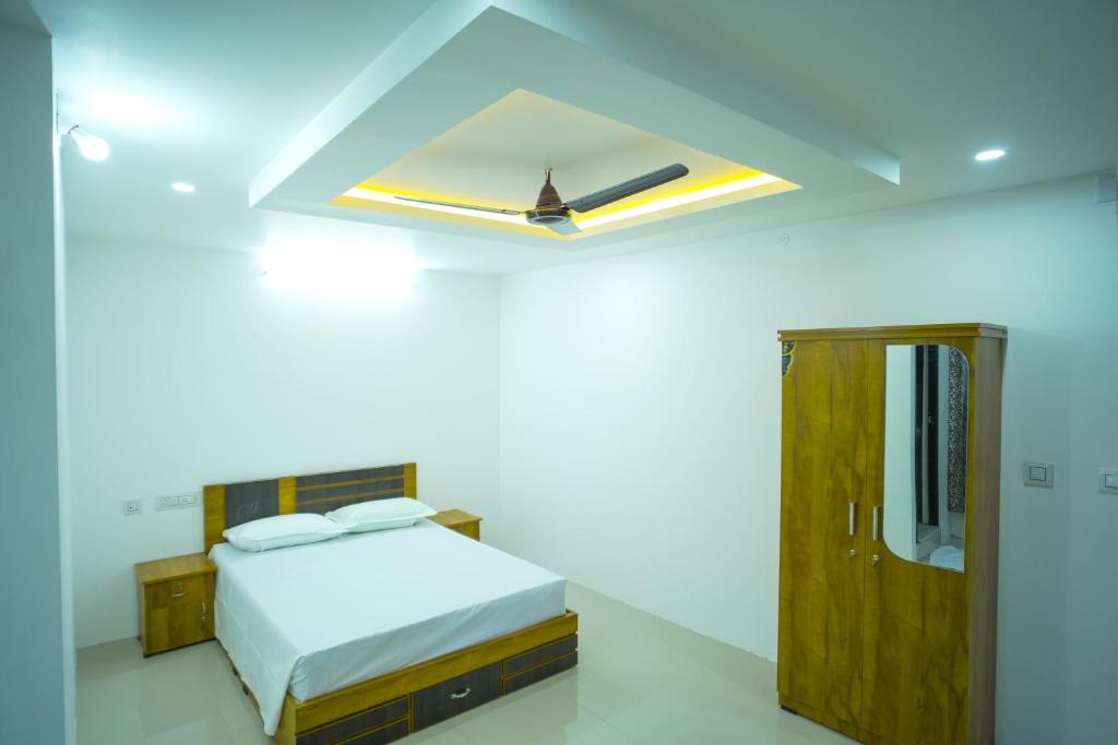 a white bedroom with a bed and a skylight at PIOUS B RESIDENCY in Mundakāyam