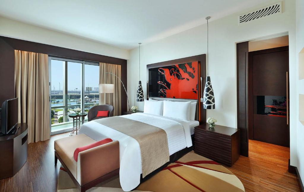a hotel room with a large bed and a balcony at Marriott Hotel Al Forsan, Abu Dhabi in Abu Dhabi
