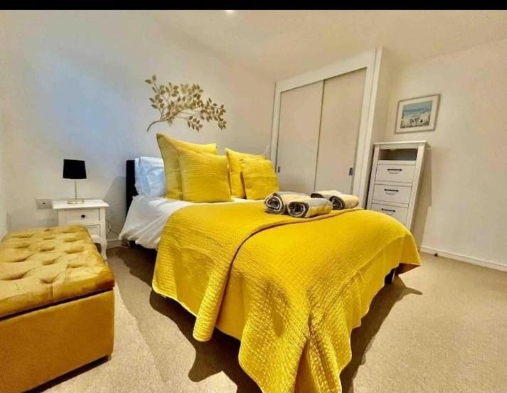 ein Schlafzimmer mit einem gelben Bett mit einer gelben Decke in der Unterkunft Gorgeous apartment with free parking & breakfast near city centre & midday checkout in Bristol