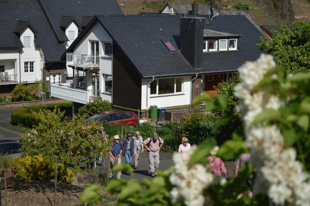 Eine Gruppe von Menschen, die in einem Haus auf einer Straße spazieren in der Unterkunft Weingut im Moselkrampen in Ellenz-Poltersdorf
