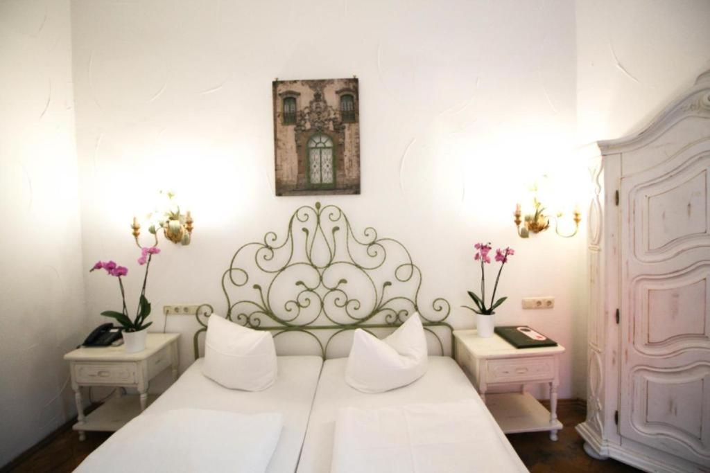 a bedroom with a white bed with white pillows at Hotel Seibel in Munich