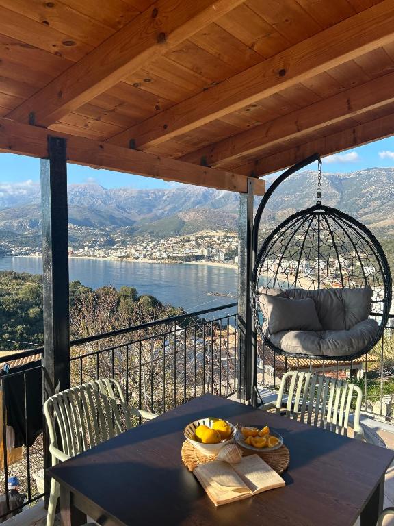 a table on a balcony with a view of the water at Hostel on the Hill - by Filikuri Beach in Himare