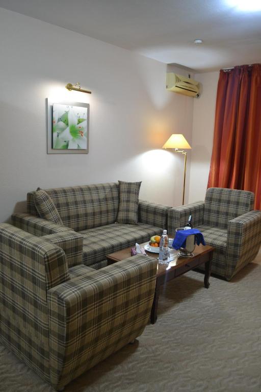 Sala de estar con 2 sofás y mesa de centro en Tengri Hotel, en Atyraū