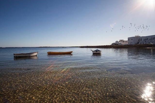 Tre barche sedute in acqua su una spiaggia di Apartment Orzola Vista Mar a Órzola