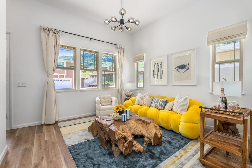 a living room with a yellow couch and a table at @Marbella Lane - 7BR home w/ Mountain+Ocean Views in Waianae