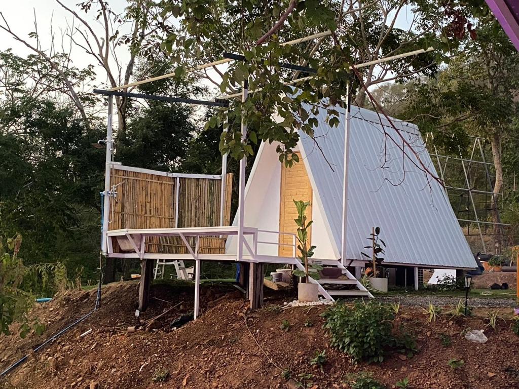 ein winziges Haus mit einer Veranda und einem Schuppen in der Unterkunft Tid Khao Glamping & Bar in Tha Kradan