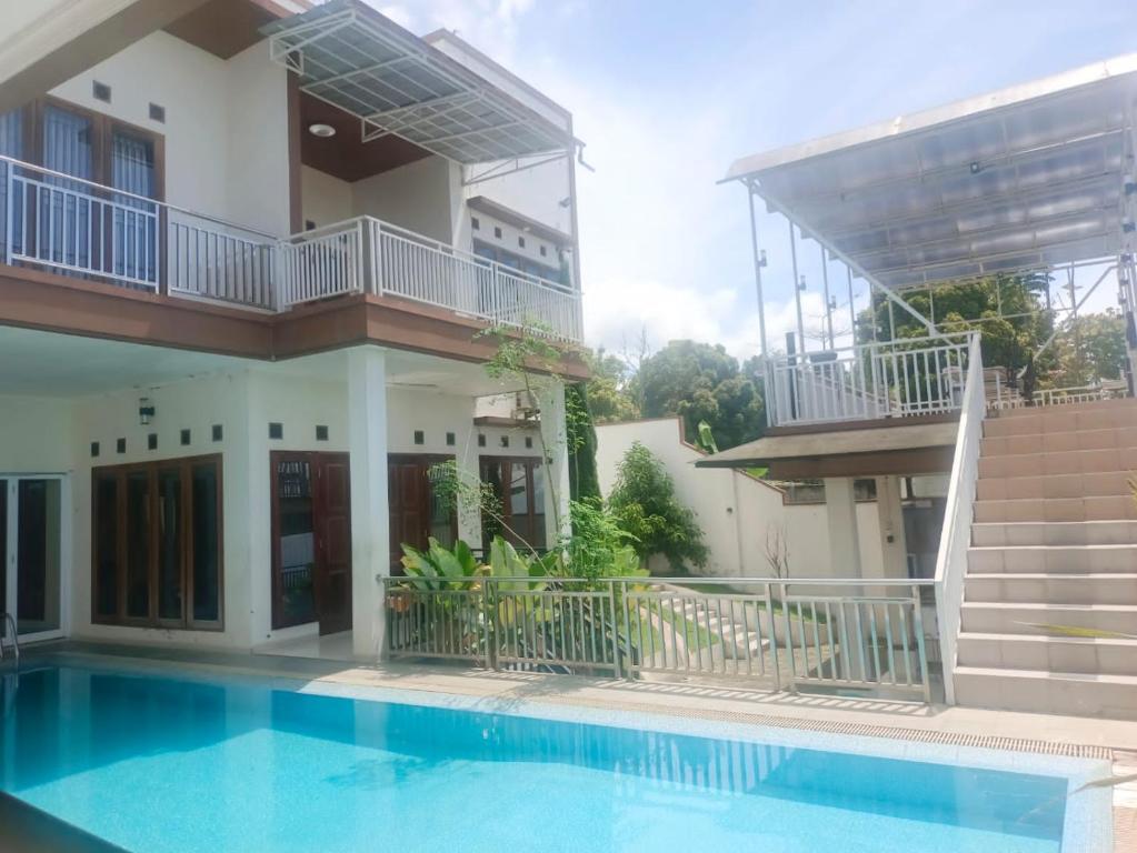 una casa con una piscina di fronte di Villa Madasaeda by GroRental a Panjadakan
