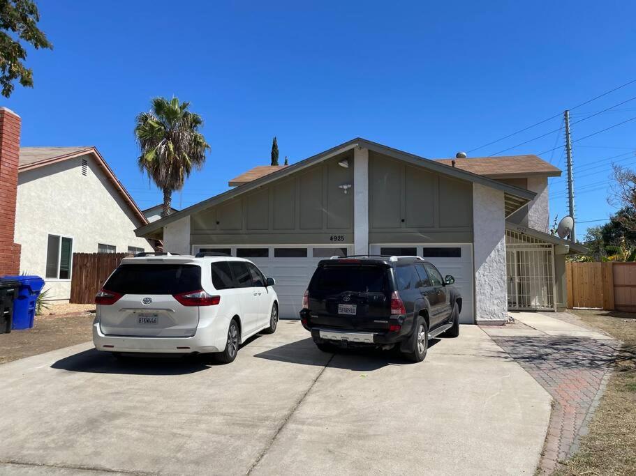 two cars parked in a driveway in front of a house at Spacious 1670 sq ft Single Home with Garage, AC, Centrally Located in San Diego
