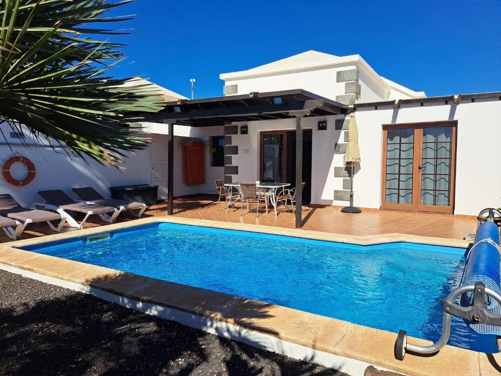 a swimming pool in front of a house at Villa de la Paz in Playa Blanca