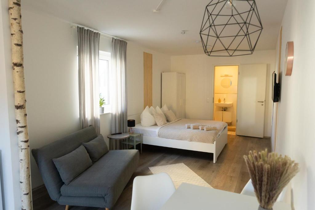 sypialnia z łóżkiem, kanapą i krzesłem w obiekcie HUGOS Studio Apartment w mieście Bensheim
