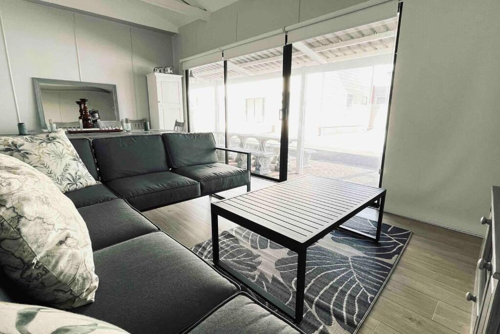 a living room with a couch and a table at The Perfect Hartenbos Holiday Home in Mossel Bay