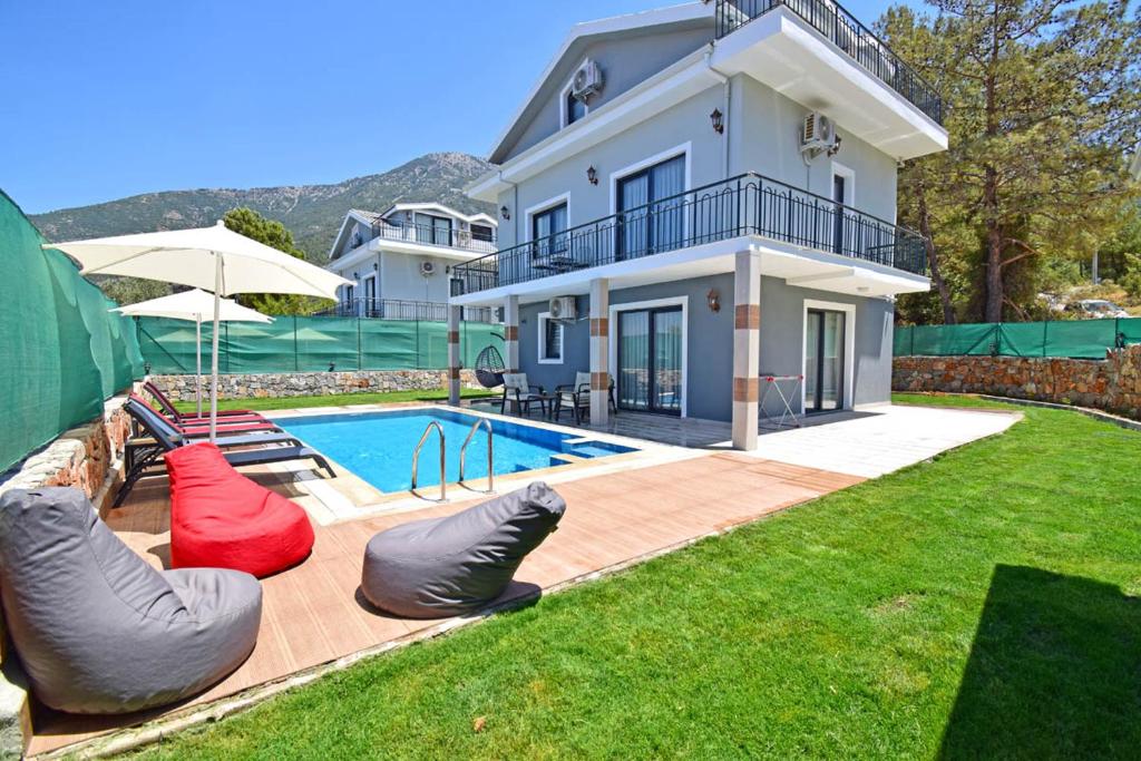 a house with a swimming pool with bean bags in the yard at Villa Kozalak 1 in Fethiye