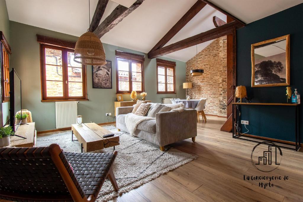 a living room with a couch and a table at The Nest, parking, centre, vue sur la Cathédrale in Albi