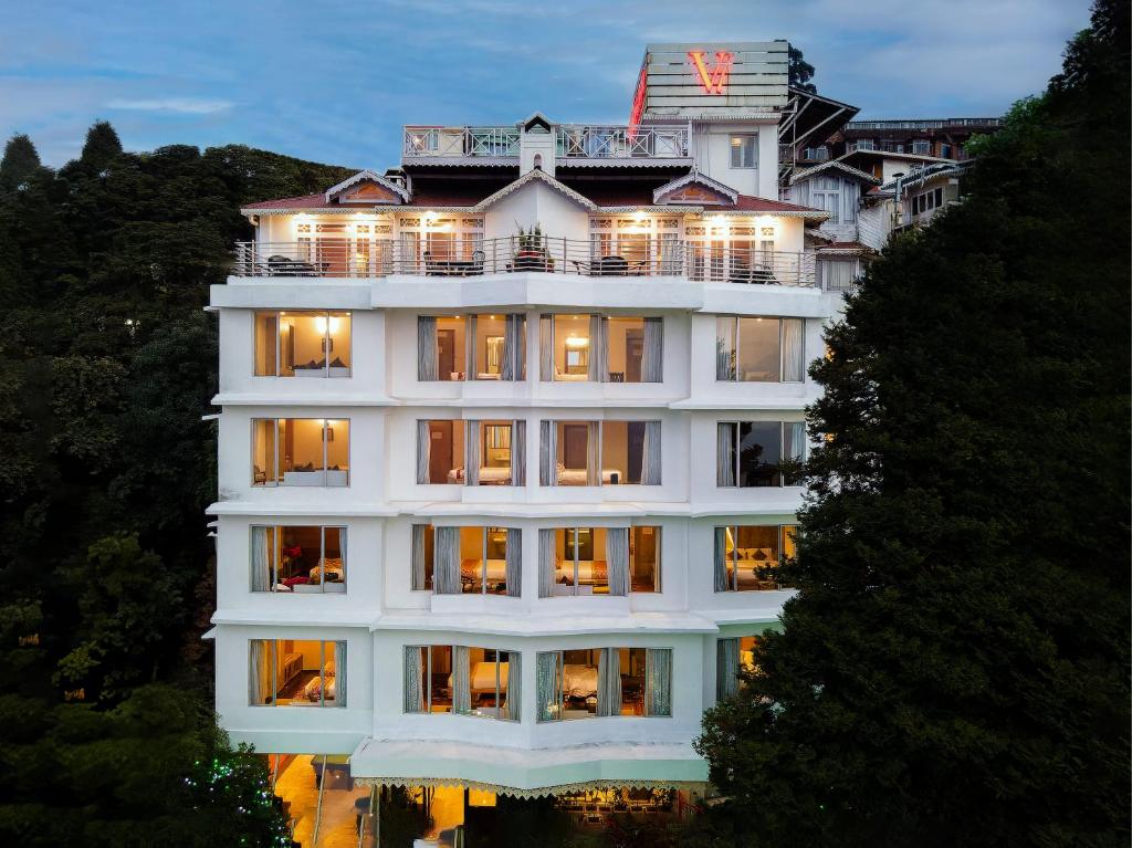 un gran edificio blanco con luces encendidas en Hotel Viceroy, en Darjeeling