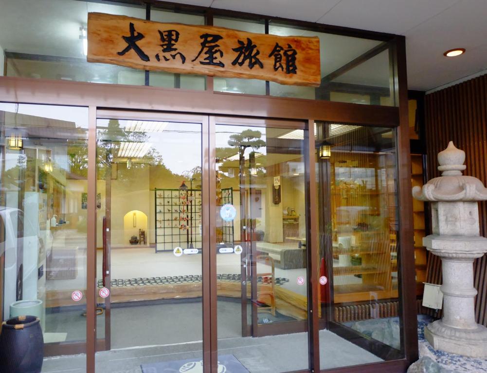 un frente de tienda con una señal sobre las puertas en Daikokuya Ryokan, en Hakodate