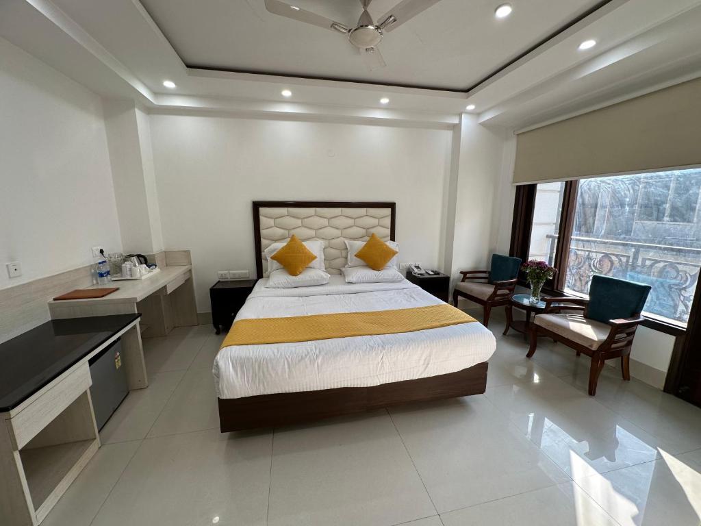 um quarto com uma cama grande, uma secretária e uma cadeira. em Lemon Green Residency - Hotel and Serviced Apartments em Nova Deli