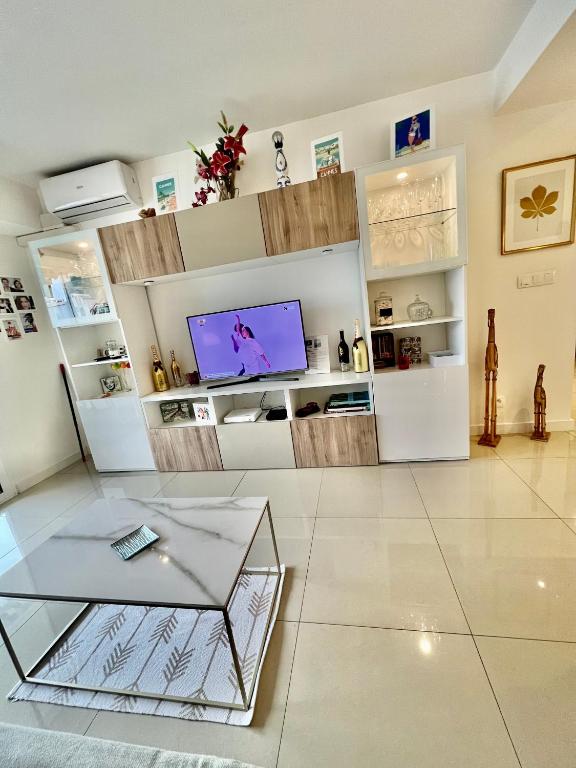 a living room with a glass coffee table and a tv at Appartement Cosy Calme Central-Terrasse Proche Palais in Cannes