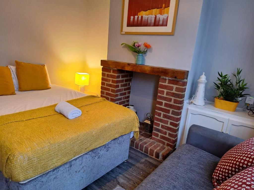 a bedroom with a bed and a brick fireplace at Ferndale House-Huku Kwetu Luton -Spacious 4 Bedroom House - Suitable & Affordable Group Accommodation - Business Travellers in Luton
