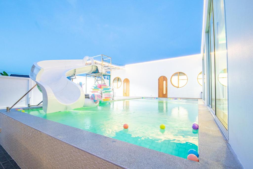 een binnenzwembad met een glijbaan bij V Pool Villa Sattahip in Sattahip