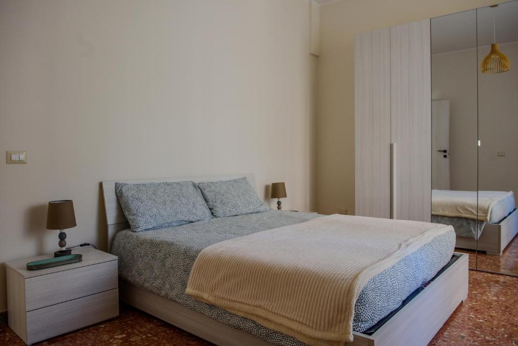 a bedroom with a large bed and a mirror at La Casa di Betty in Lido di Ostia