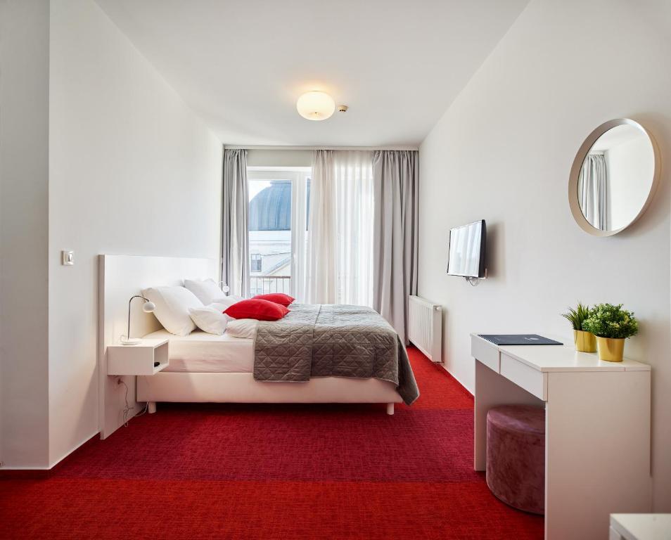 1 dormitorio con 1 cama con alfombra roja en SkyLux Apartments by Irundo en Zagreb