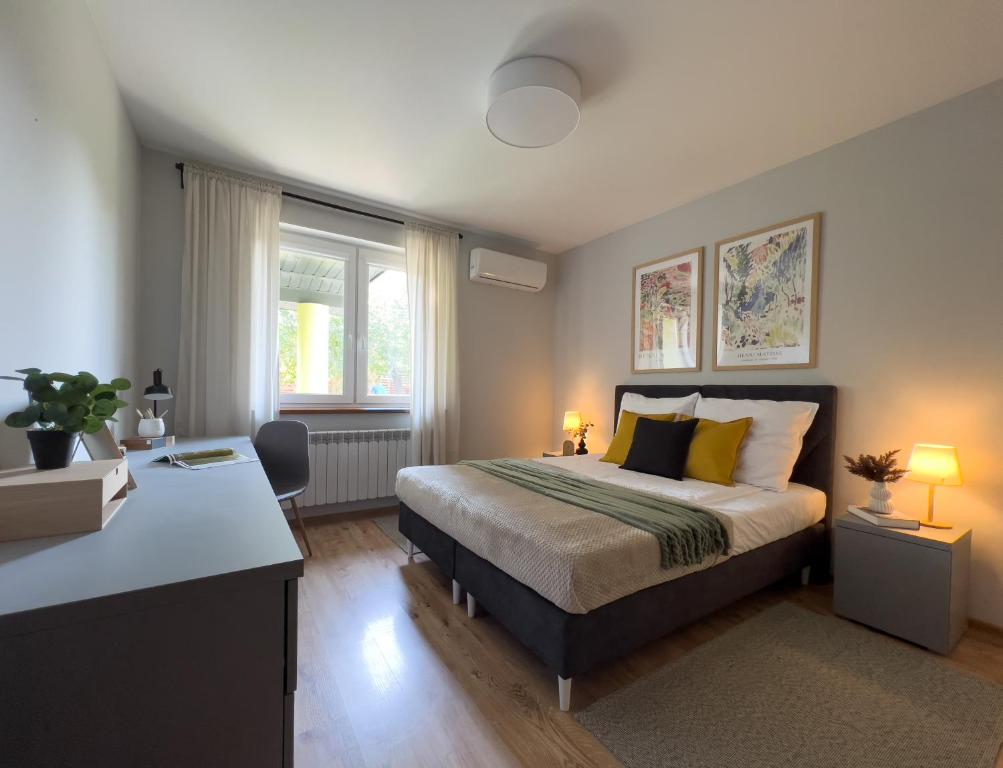 1 dormitorio con 1 cama y escritorio con 2 lámparas en Garden House - OSTOYA, en Jasionka