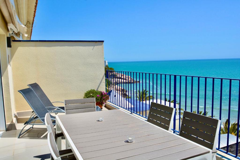 balcón con mesa, sillas y vistas al océano en Marina Duplex by Hello Homes Sitges en Sitges