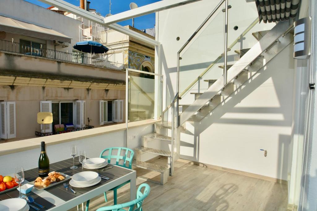 a balcony with a table with food and a staircase at Blue Serenity by Hello Homes Sitges in Sitges