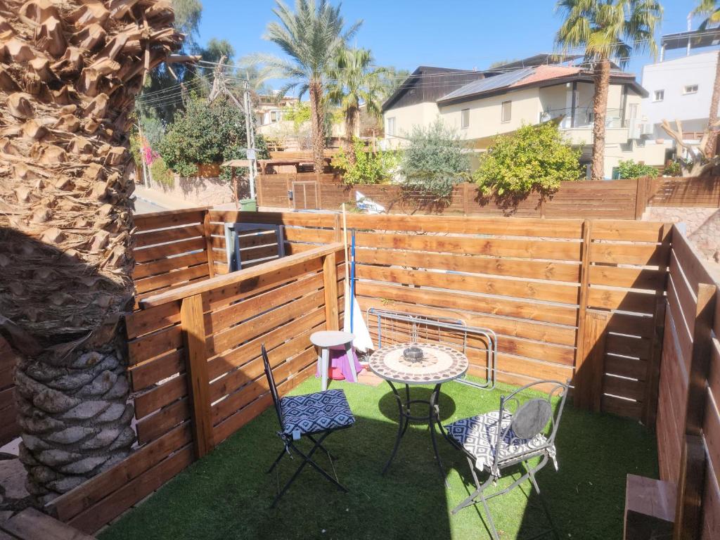 eine Terrasse mit Tisch und Stühlen und einem Zaun in der Unterkunft Shalom&#39;s place in Eilat