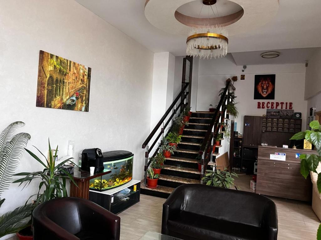 a lobby with a staircase with plants and a television at Live Tulcea Hotel in Tulcea