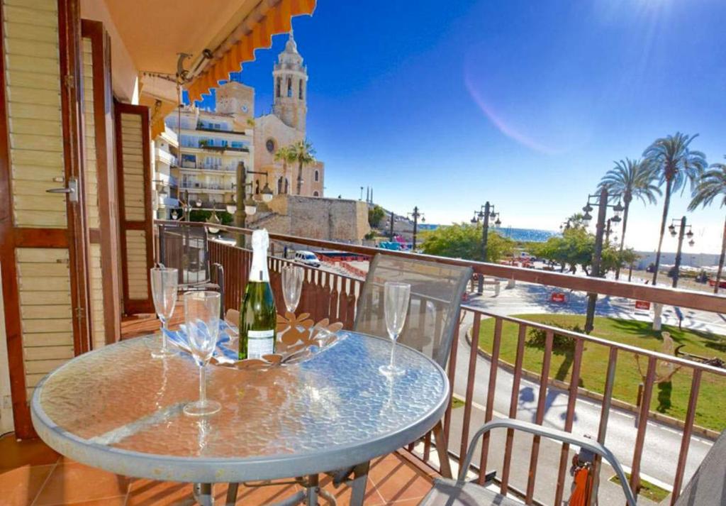 una mesa con copas y una botella de vino en el balcón en Soleil by Hello Homes Sitges, en Sitges