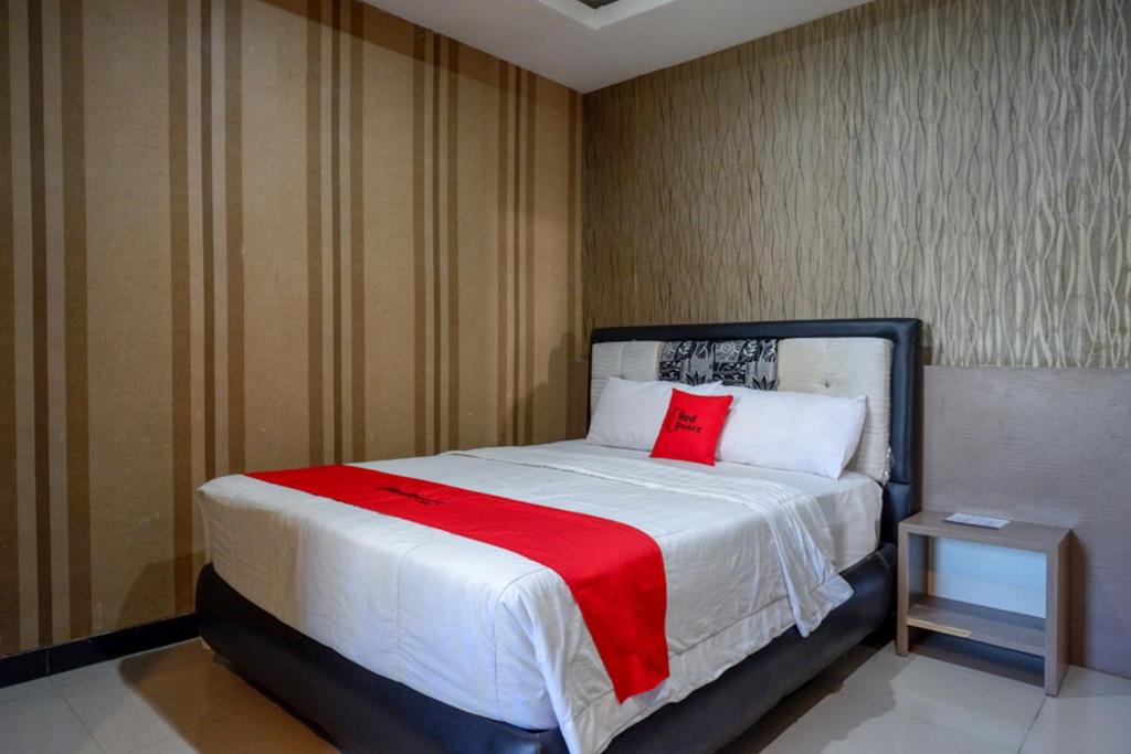 una camera da letto con un cuscino rosso di RedDoorz at Jalan Emmy Saelan Palu a Palu