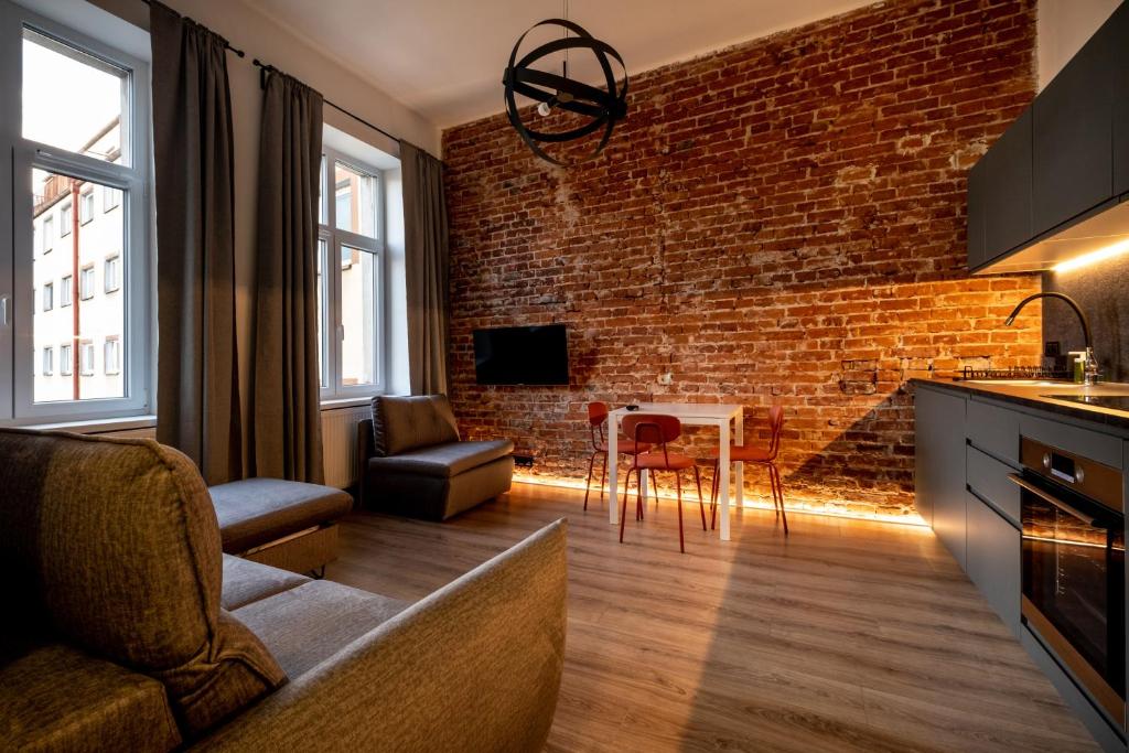 a kitchen and living room with a brick wall at RentPlanet - Apartamenty Krasińskiego in Wrocław