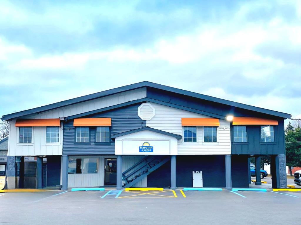 a blue and white building with a parking lot at Days Inn and Suites by Wyndham Port Huron in Port Huron