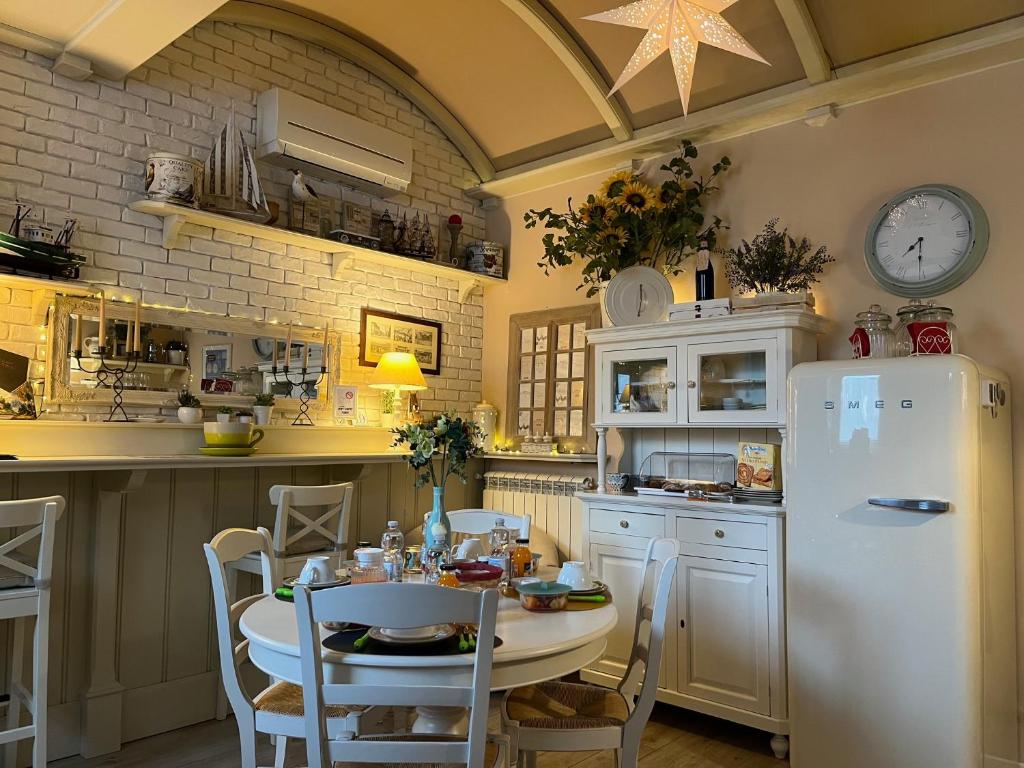 eine Küche mit einem Tisch und einem weißen Kühlschrank in der Unterkunft Serendipity B&B Pescara in Pescara