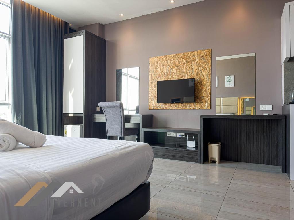 a hotel room with a bed and a tv at Stirling Suites by Evernent in Miri